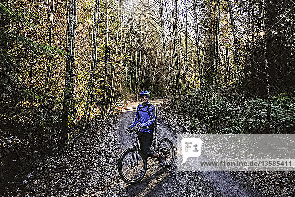Portrait confident man mountain biking in autumn woods  Squamish  BC  Canada