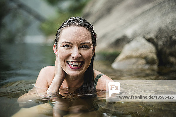 Porträt lächelnd  schöne junge Frau schwimmt im See