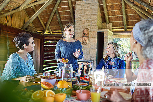 Friends enjoying healthy breakfast in hut during yoga retreat