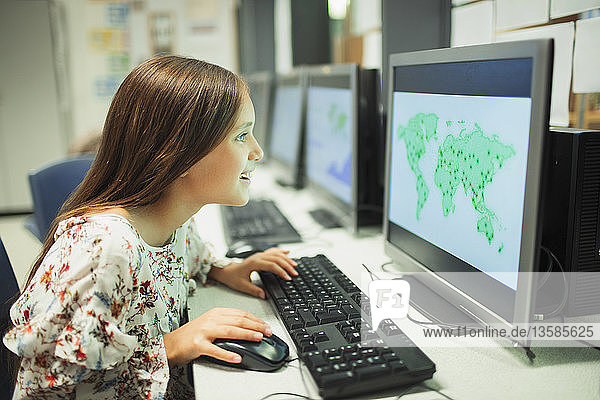 Neugierige Schülerin der Junior High School betrachtet eine Karte auf dem Computer im Klassenzimmer