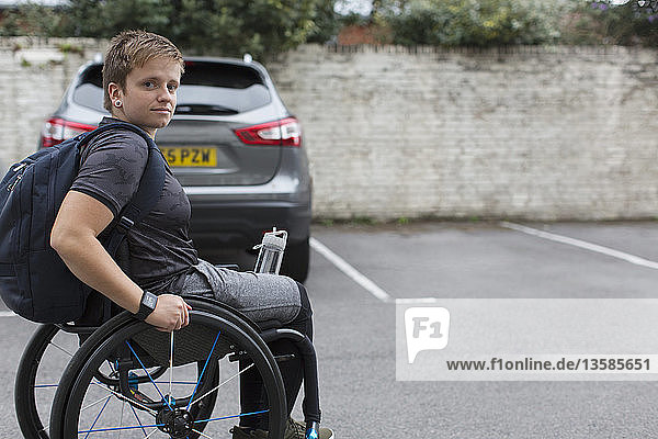 Porträt einer selbstbewussten jungen Studentin im Rollstuhl auf einem Parkplatz