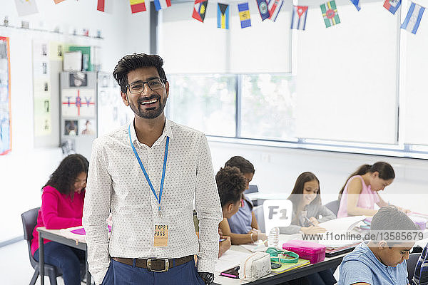 Porträt lächelnder  selbstbewusster männlicher Lehrer im Klassenzimmer