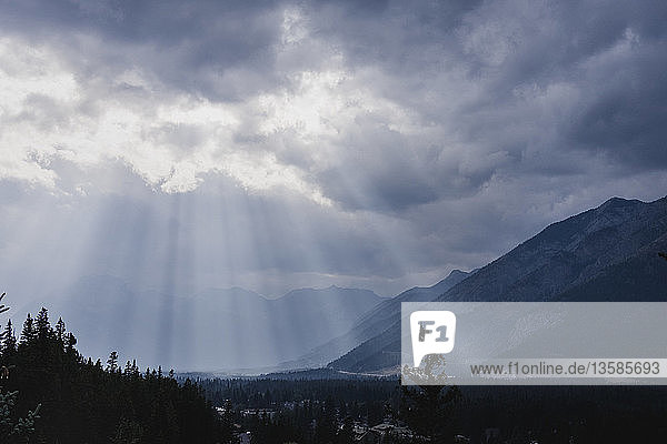 Sunbeams breaking through clouds over idyllic mountains and valley  Banff  Alberta  Canada
