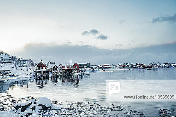Ruhiger Blick auf verschneites Fischerdorf am Wasser  Reine  Lofoten-Inseln  Norwegen