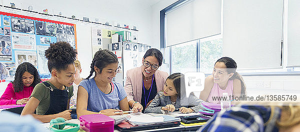 Weibliche Lehrerin und Junior High School Mädchen Schüler am Schreibtisch im Klassenzimmer