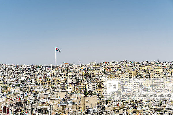Die jordanische Flagge weht über den sonnigen Gebäuden der Stadt  Amman  Jordanien