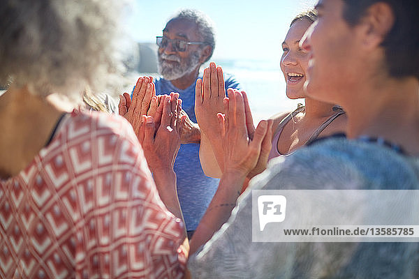 Friends with hands clasped in circle enjoying yoga retreat