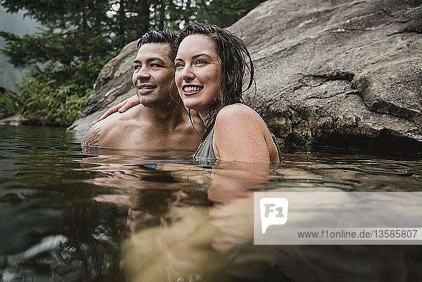 Zärtliches junges Paar beim Schwimmen im See