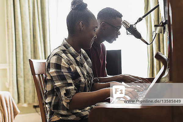 Bruder und Schwester im Teenageralter spielen Klavier