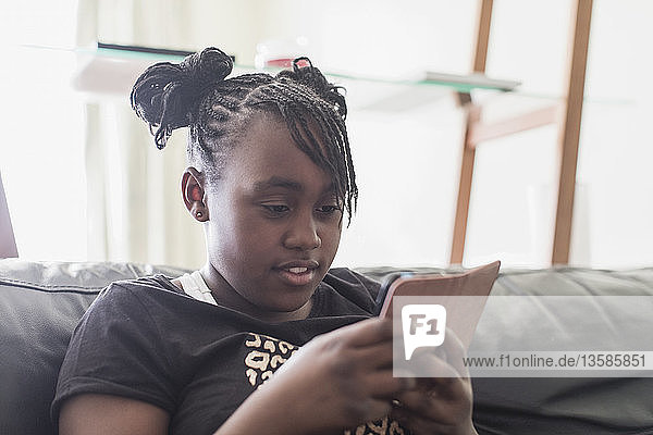 Tweener-Mädchen schreibt SMS mit Smartphone