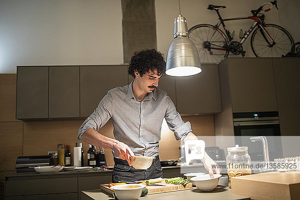 Man cooking dinner in apartment kitchen