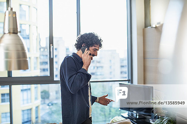 Mann spricht in einer städtischen Wohnung mit einem Smartphone