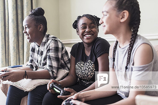 Carefree tween girl friends playing video game