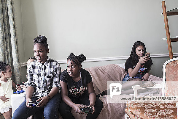 Tween Freundinnen spielen ein Videospiel auf dem Wohnzimmersofa