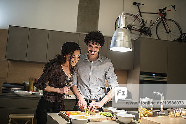 Couple cutting vegetables  cooking dinner in apartment kitchen