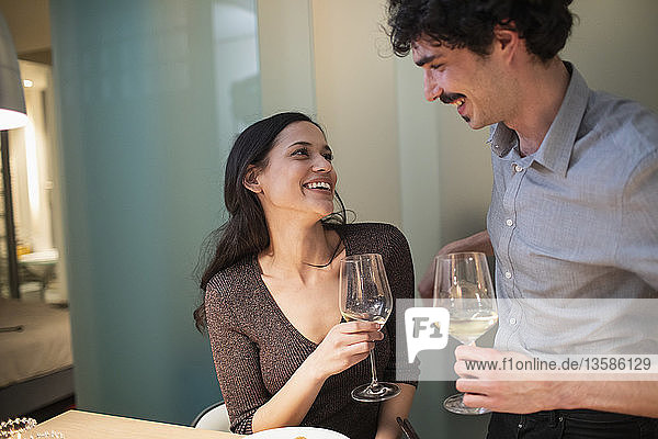 Glückliches Paar trinkt Weißwein