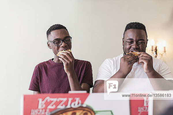Brüder im Teenageralter essen Pizza