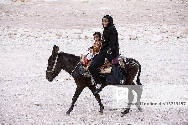 Bedouin woman and child on a donkey in Petra   Petra  Jordan.