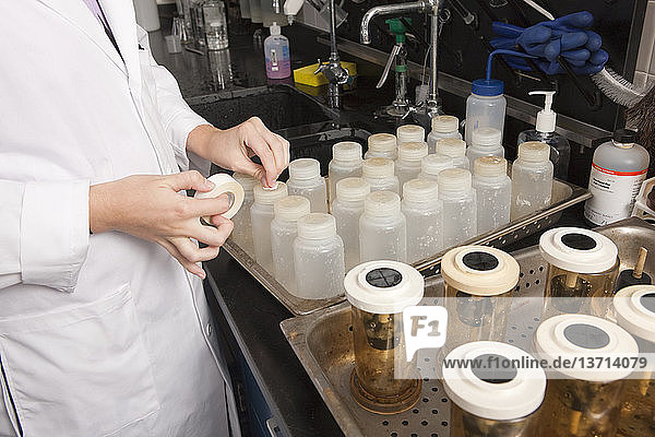 Wissenschaftlerin beim Beschriften der Chemikalienflaschen im Labor der Wasseraufbereitungsanlage