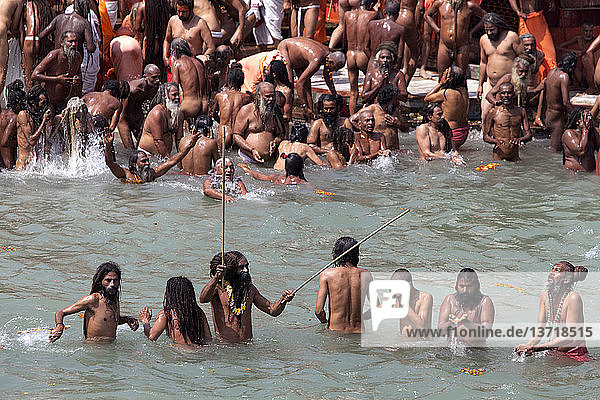 'Naga sadhus bathing in the river Ganges on the occasion of ´Somvati Amavasya´  a no moon day in the traditional Hindu calendar. During the Maha Kumbh Mela festival  the ´Shahi Snan´ (royal bath) is considered a highly auspicious bathing day. '