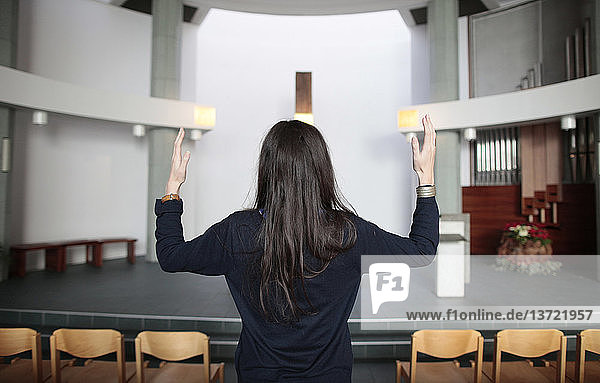 Young woman praying in a church.