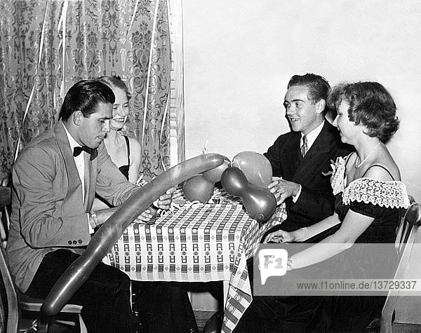 Vereinigte Staaten: 1947 Zwei Paare versuchen  sich auf einer Party mit Luftballonspielzeug zu amüsieren.