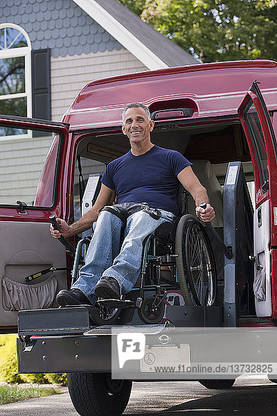 Ein Mann mit einer Rückenmarksverletzung im Rollstuhl steigt in seinen Lieferwagen ein