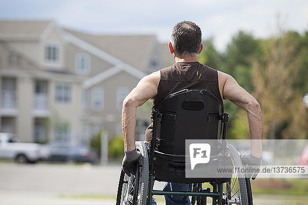Mann mit Rückenmarksverletzung sitzt im Rollstuhl
