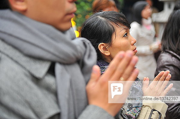 Gläubige beten in einem buddhistischen Tempel in Hanoi