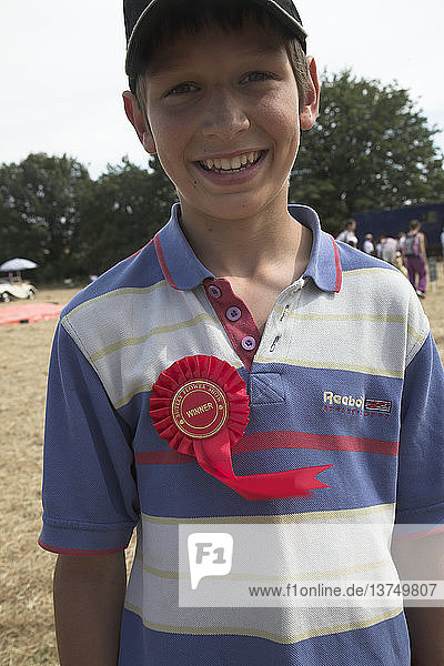 Junge trägt Rosette als Gewinner - Modell Freigegeben