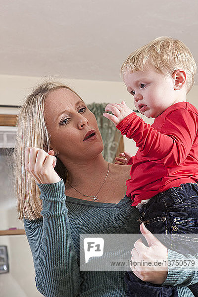 Frau gebärdet das Wort ´Milk´ in amerikanischer Zeichensprache  während sie mit ihrem Sohn kommuniziert