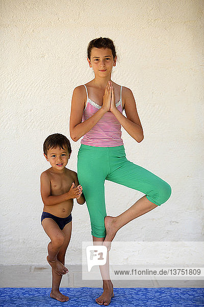 Mädchen und Junge üben Yoga