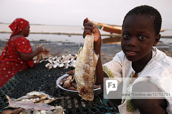 Junge zeigt von seiner Mutter geräucherten Fisch
