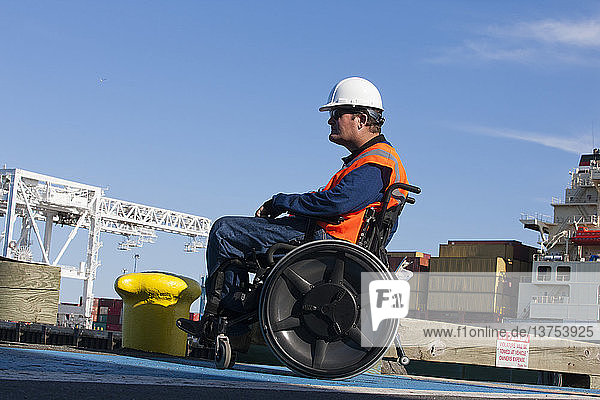 Transportingenieur im Rollstuhl bei der Inspektion von Schiffscontainern im Verschiffungshafen