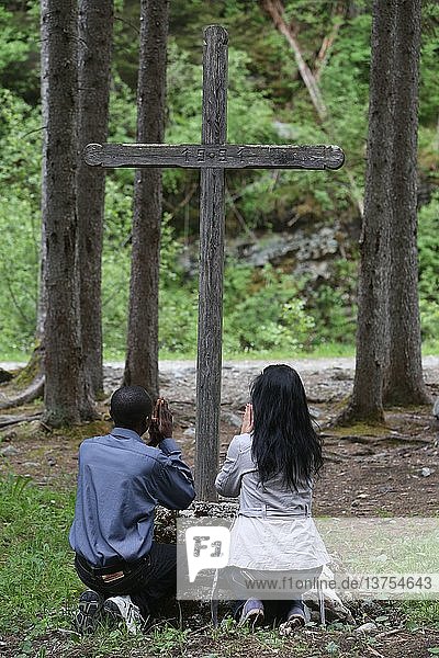 Mann und Frau beten in den Bergen.