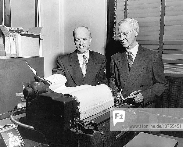 Cleveland  Ohio: ca. 1954 Zwei leitende Angestellte betrachten ausgedruckte Datenblätter bei der Erie Railroad Company.