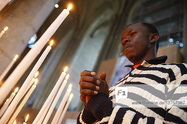 Man praying with candles in church