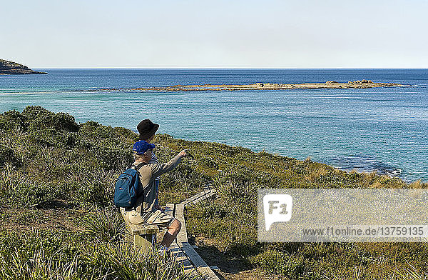 Bushwalkers resting on coastal bench  Murramarang National Park  New South Wales  Australia