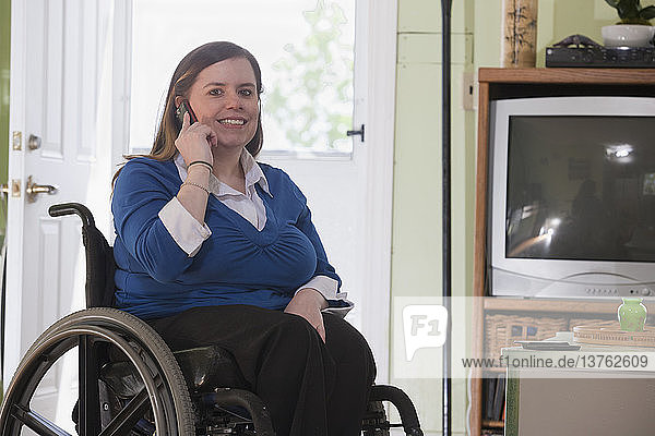 Woman with Spina Bifida in a wheelchair talking on a mobile phone