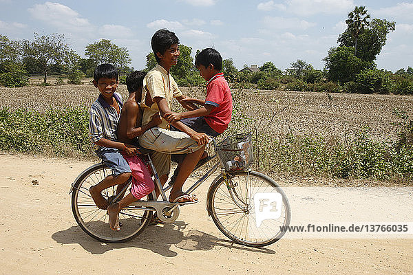 Four cambodian boys on a bicycle
