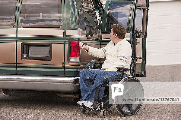 Ein Mann mit einer Rückenmarksverletzung benutzt eine magnetische Fernbedienung  um sein zugängliches Fahrzeug zu schließen