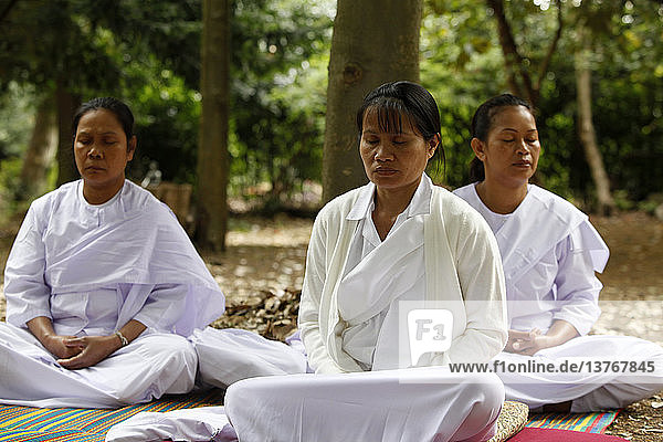 Retreat-Teilnehmer meditieren im Garten des Buddhapadipa-Tempels