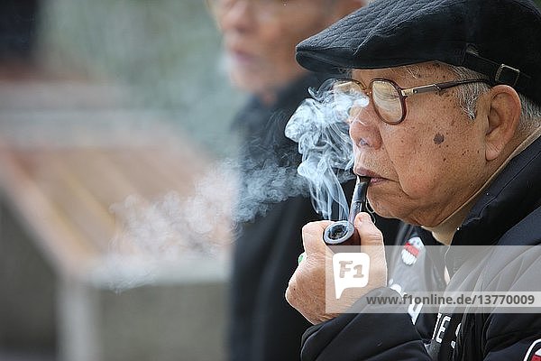 Alter Mann raucht eine Pfeife  Macau  China.