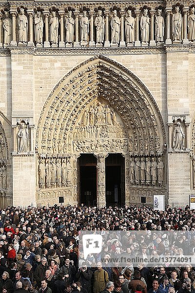 Menschen versammeln sich vor der Kathedrale Notre Dame de Paris  um das erste Läuten der neuen Glocken zu hören.