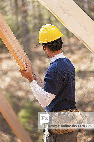 Carpenter placing a rafter