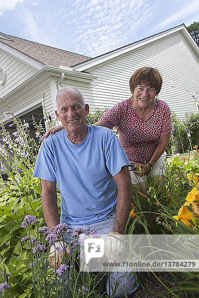Portrait of a senior couple preparing to plant flowers in garden