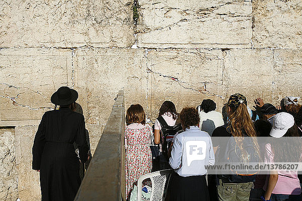 Mann und Frau beten getrennt an der Klagemauer
