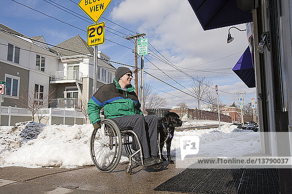 Frau mit Multipler Sklerose vor einem Geschäft mit einem Diensthund