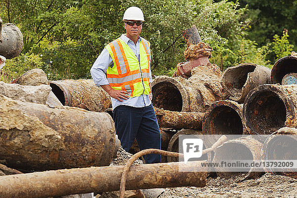 Ingenieur mit alten Wasserleitungen  die aus dem städtischen Leitungsnetz entfernt wurden