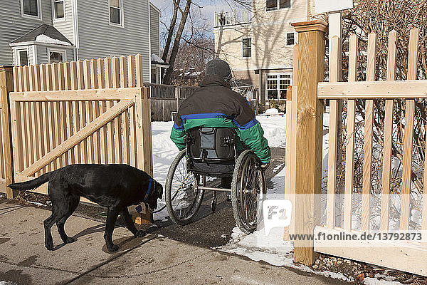 Frau mit Multipler Sklerose geht im Winter mit einem Diensthund nach Hause